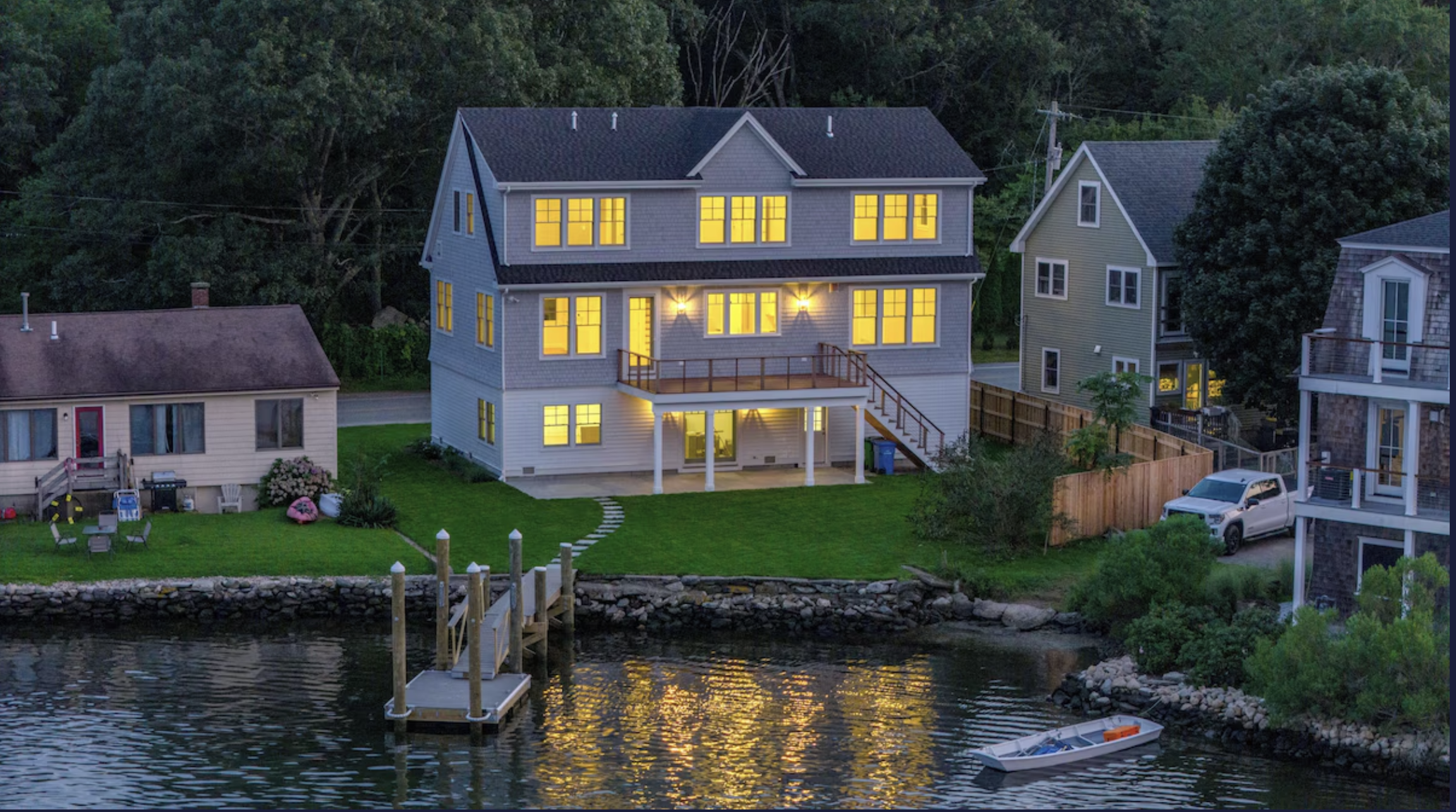 Narragansett waterfront home illuminated at dusk